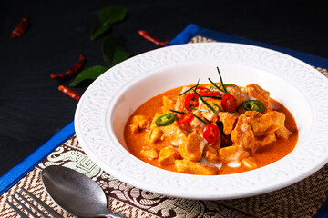 Thai Food concept Authentic Thai chicken Panang Curry, Panang Kai in ceramic bowl on black background with copy space