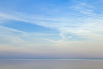 Fototapeta premium Beautiful sunset on sea, pastel colors and reflections on water, calm nature landscape with colorful clouds