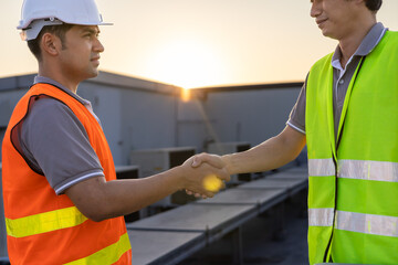 Businessmen  shaking hands with Asian construction engineer at the building site. The team of workers concluded an agreement. Inspection, checking and building concept.