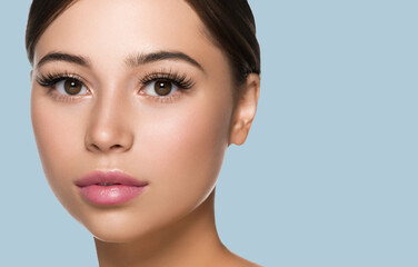 Fototapeta premium Freckle face woman with healthy beauty skin big lashes and beautiful eyes. Color background.