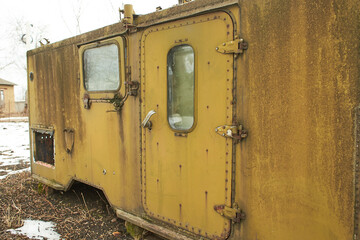 Green old military trailer stands abandoned on the street