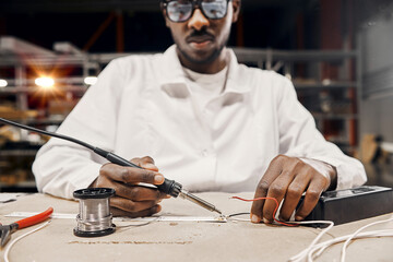 Hands soldering lamps and wires