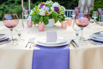 Flower table decorations for holidays and wedding dinner. Table set for holiday, event, party or wedding reception in outdoor restaurant.