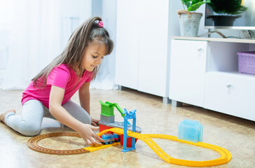 baby game. Little clever caucasian child playing colorful toy railway and train for early development.