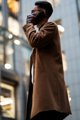 portrait of a young businessman talking on the phone near the office