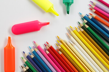 Multicolored markers and pencils on white paper. Drawing materials.