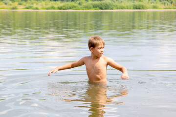 boy on a hot summer day goes into the river