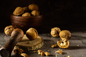 Walnuts on a dark vintage background, walnuts in a clay bowl. Chopped walnuts