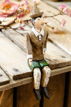 figurine of pinocchio sitting on a wooden table top