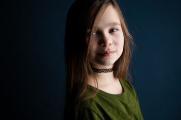 Portrait of a cute little 9 year old girl on dark background 