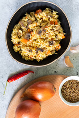 Vegetarian pilaf with mushrooms on a light background. Vertical photo. Top view.