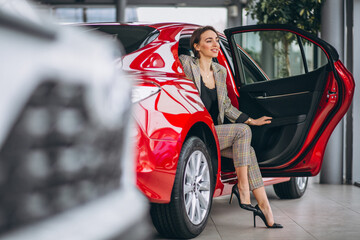 Business woman sitting in a red car