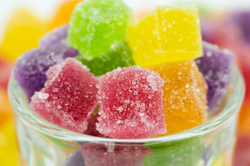 Cube sugary jelly candy in glass container.