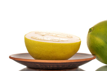 One half sweet pomelo on a clay dish, macro, isolated on white.