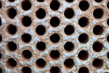 Tube sheet plate of heat exchanger or boiler closeup texture macro industrial background with insoluble hard mineral deposits salts scale welding seams and corrosion. Trypophobia concept.