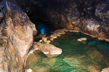 Stalactite, stalagmite on the walls of the cave. Cave lake. Template for design.