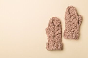 Brown winter mittens on wooden background. Top view