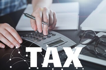 Businessman using the calculator to fill in the income tax online return form for payment.
