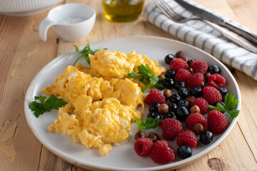 Low carb breakfast plate with scrambled eggs, fresh berries and hazelnuts