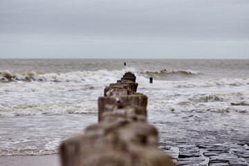 North Sea with wooden poles in a cloudy and windy day.