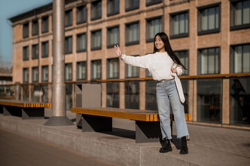 Girl standing near bench with raised hand in greeting
