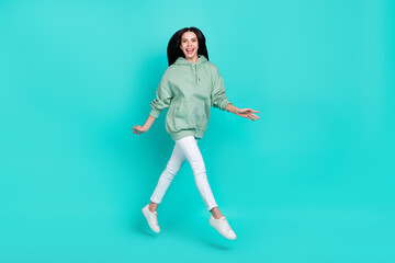 Fototapeta na wymiar Full body photo of cute young brunette lady run wear hoodie trousers shoes isolated on teal background