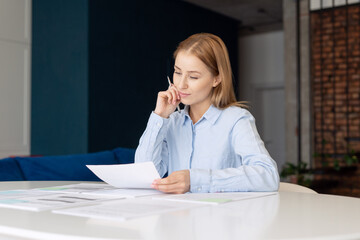 Pensive girl carefully examining document from home office