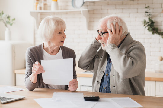 Senior elderly grandparents couple feeling shock sad in debts, bunkruptcy, negative test results, mortgage, divorce certificate contract pension, doing paperwork at home