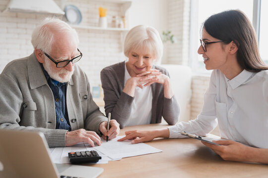 Consultant financial adviser specialist dealing with senior elderly grandparents couple clients, discuss health insurance, bank account history. Family spouses customers consult with relator broker.