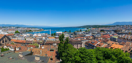 Naklejka na ściany i meble Panoramic city view and Jet d'Eau fountain on Lake Geneva. Taken from St. Peter's Cathedral, Switzerland. The fountain sprays upwards to 120 meters high.