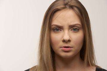 Fototapeta premium Portrait of sad young woman emotional alone in white background