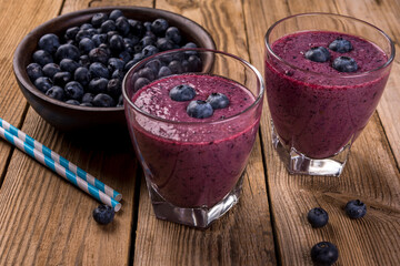 Blueberry cocktail (smothie) in a glass on a rustic wooden background.
