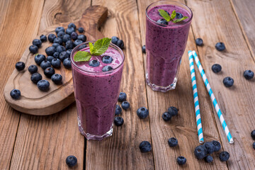 Blueberry cocktail (smothie) in a glass on a rustic wooden background.
