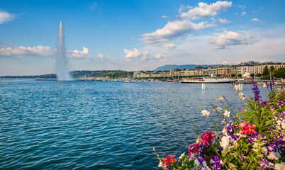 Jet d'Eau fountain on Lake Geneva in the late evening, Switzerland. The fountain sprays upwards to...