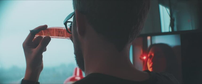 Young Man examines 35mm analog filmstrip