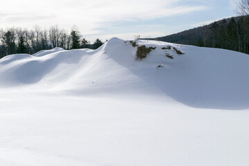 Fototapeta na wymiar Snowy mound in field with dirt showing