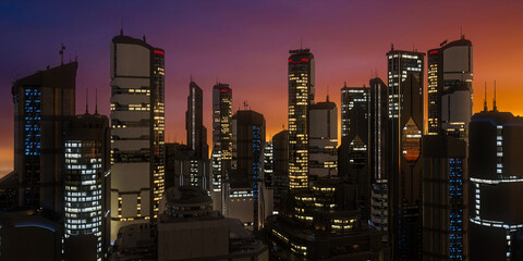 Wide panoramic view of a futuristic downtown cityscape with skyscraper buildings lit up at sunset. 3D rendering. - obrazy, fototapety, plakaty