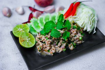 Minced pork larb served with fresh vegetables, a popular Thai food in the Northeast. In Thai, it is smoother than 