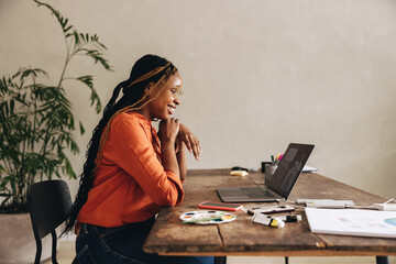 Happy graphic designer attending a virtual meeting