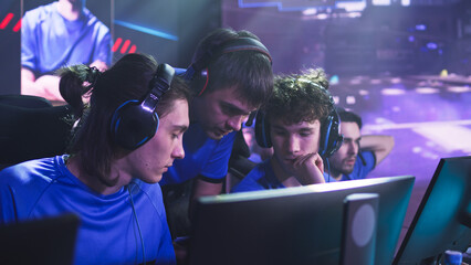 Esportsman gamer in headsets listening to trainer explaining game strategy at start of professional esports competition © Framestock