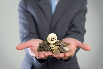 Businessman giving golden bitcoin to another human. two hands exchanging cryptocurrency.