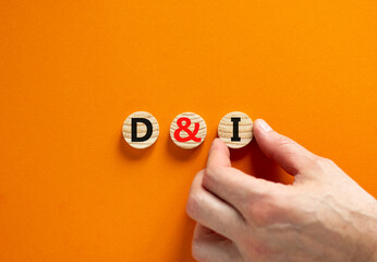 D and I, Diversity and inclusion symbol. Concept words D and I, diversity and inclusion on wooden circles on beautiful orange background. Business, D and I, diversity and inclusion concept.