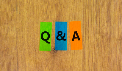 Q and A, questions and answers symbol. Concept words Q and A questions and answers on colored papers on beautiful wooden background. Business and Q and A questions and answers concept.