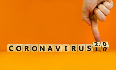 Covid-19 coronavirus 2.0 symbol. Doctor turns cubes and changes words coronavirus 1.0 to coronavirus 2.0. Beautiful orange background copy space. Medical Covid-19 coronavirus 1.0 or 2.0 concept.
