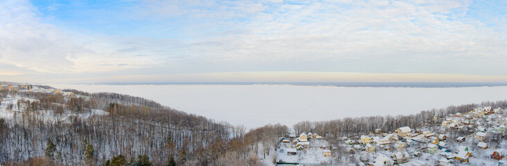 Panoramic winter landscape with wide Volga river and banks