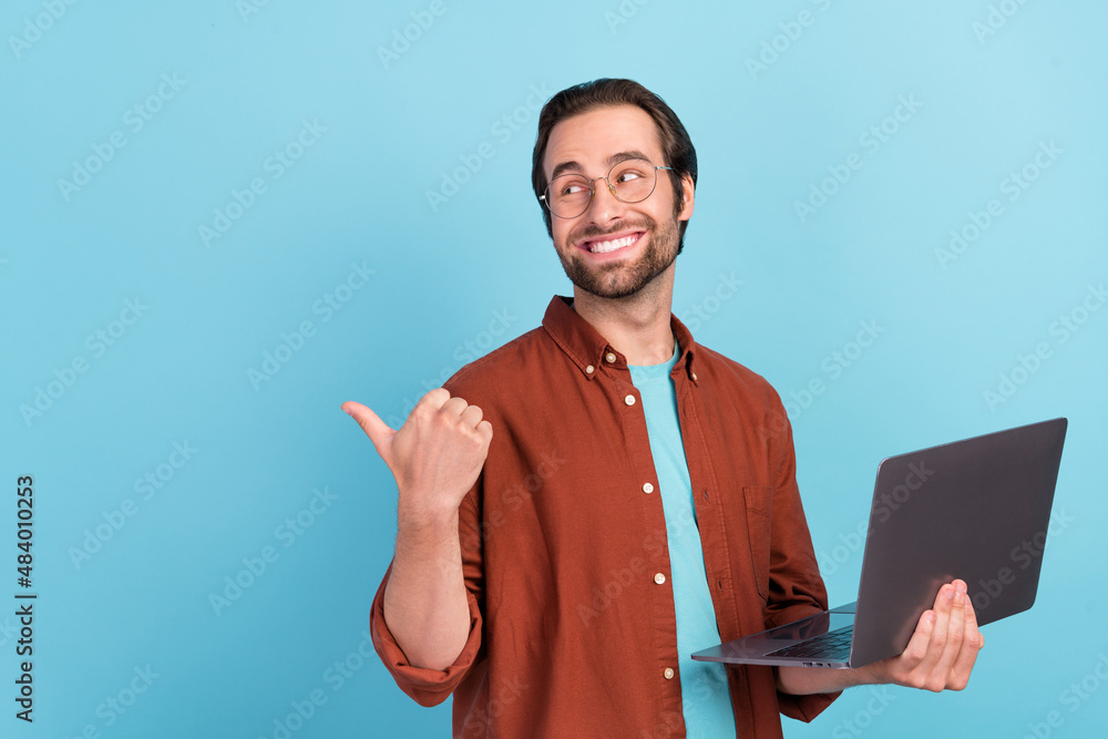 Poster Photo of manager brunet young guy hold laptop index promo wear spectacles trend fit isolated on blue color background