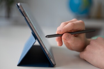 Tapping tablet screen with digital pen closeup composition