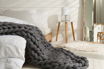 Soft chunky knit blanket on bed in room