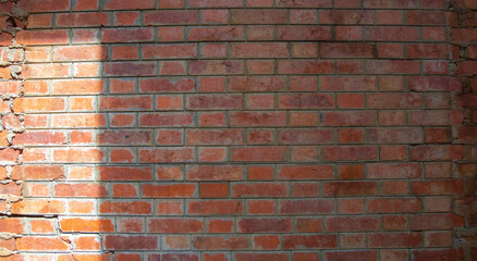light and shadow on orange old brick wall
