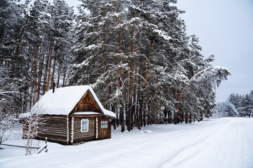 A small country house in the middle of the forest by a country road. An old forester's house. Winter forest landscapes